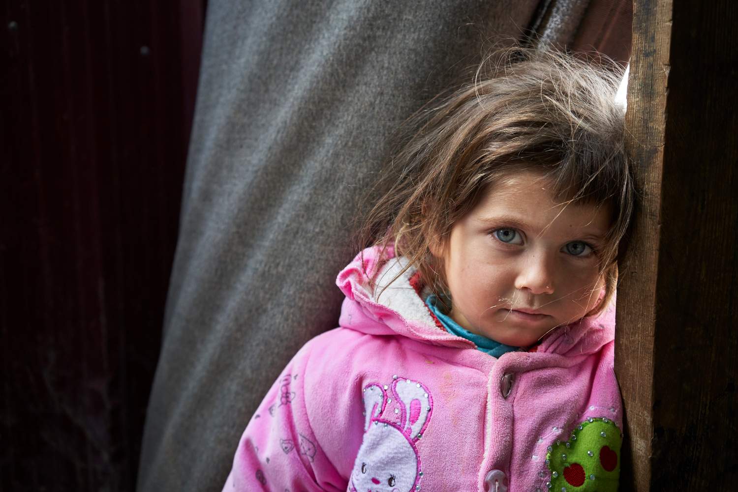 Syrian refugee Hajar, 3.5, stands in the doorway to the shelter Zeenab shares with her family in Zaatari refugee camp, Mafraq Governorate, Jordan.
