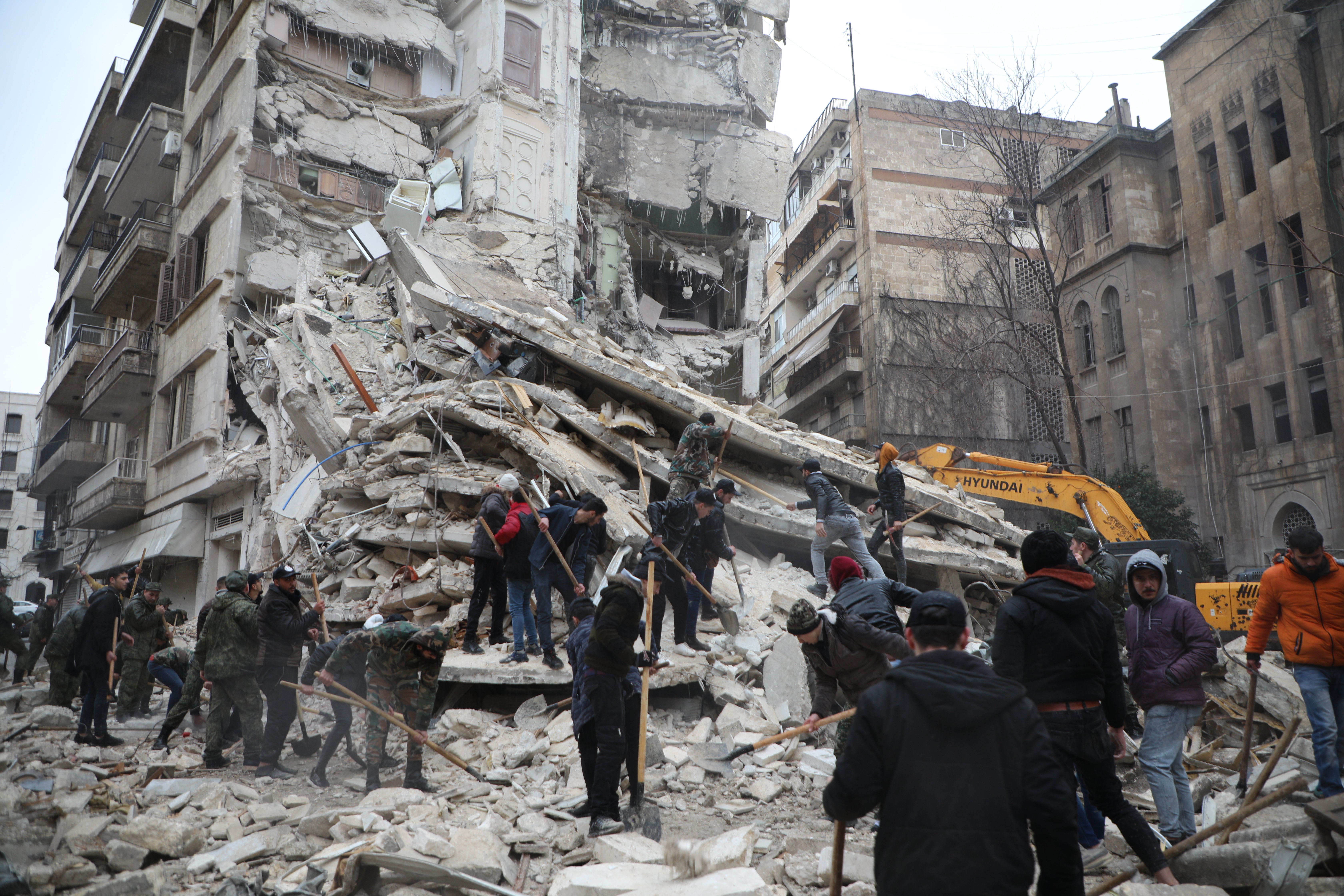 People search for survivors under the rubble of a collapsed building in the Al-Aziziyeh neighbourhood of Aleppo, Syria, after two powerful earthquakes struck the region on 6 February. So far, more than 11,000 people have been confirmed dead as a result of the 7.7 and 7.5 magnitude earthquakes that hit south-eastern Türkiye and northern Syria.