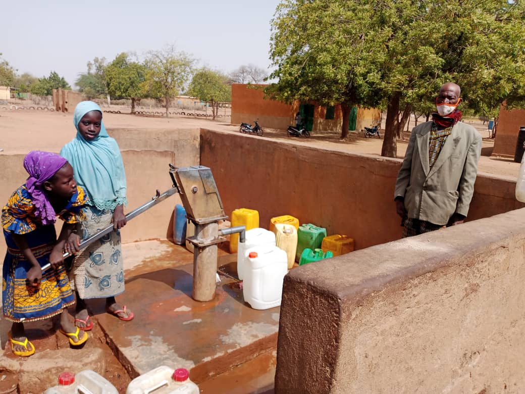 UNHCR: Sahel Emergency Retired civil servant Lambda and two of his granddaughters at a water pump in the commune of Tougouri, northern Burkina Faso.