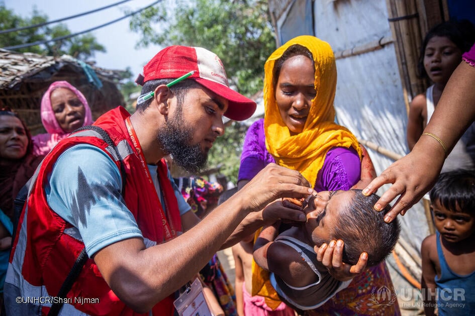 Bangladesh. A community health volunteer administers cholera medicine to a young child in the Rohingya refugee camps