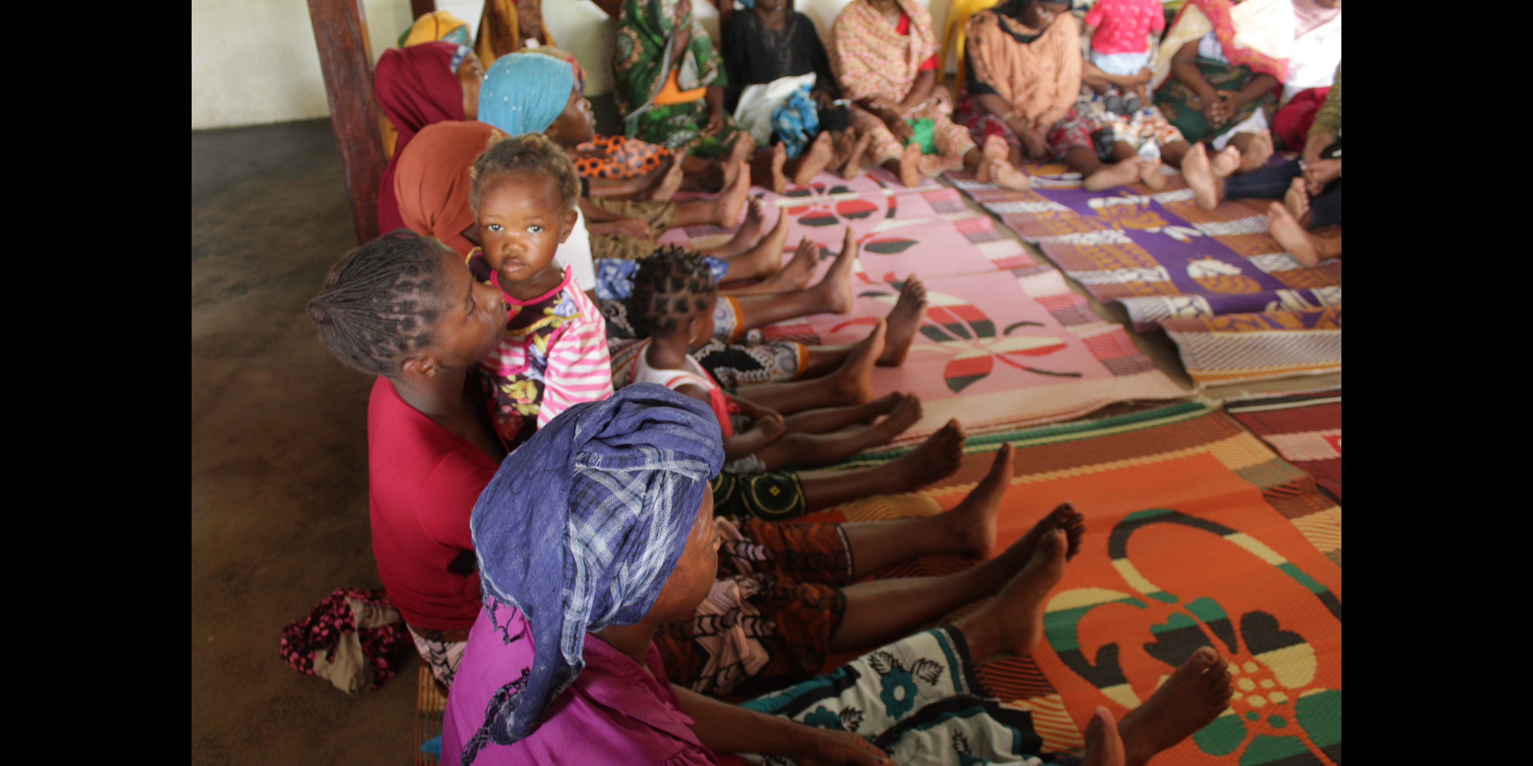 Mozambique. Displaced women and children attend group mental health session in safe space