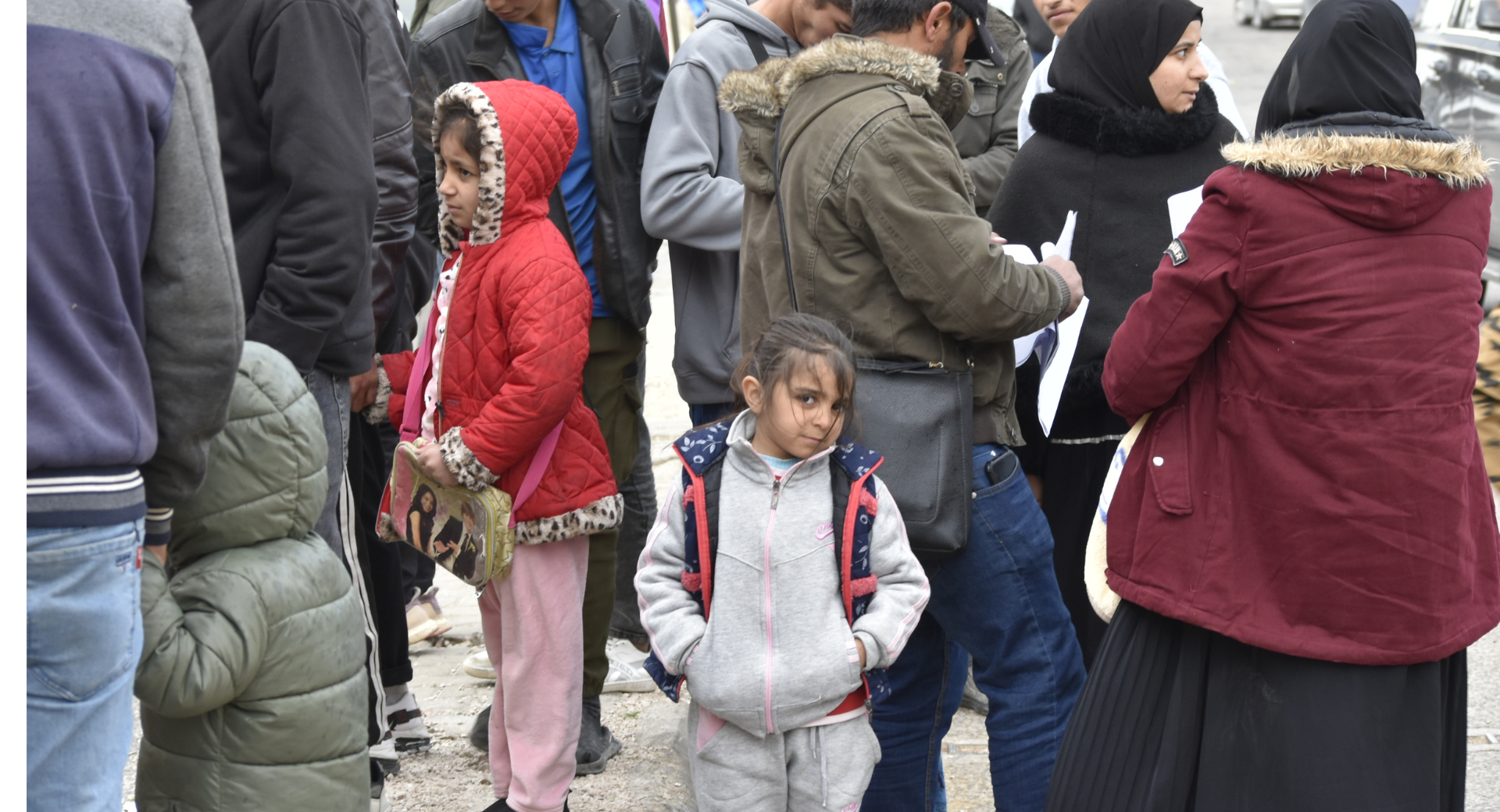 People gather at the Masnaa border point in Lebanon as they wait to cross into Syria to escape ongoing Israeli bombing and evacuation orders.