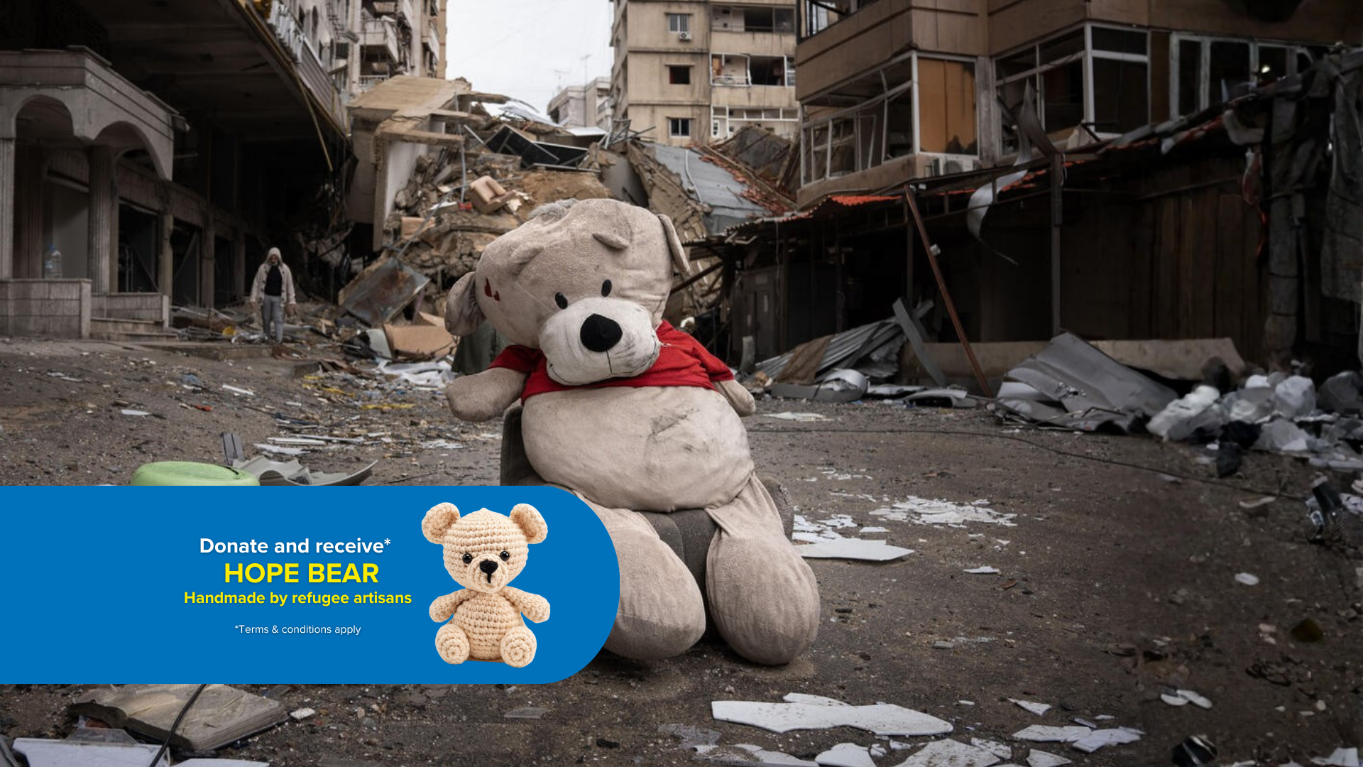 A bear plushie sits in a town destroyed by conflict