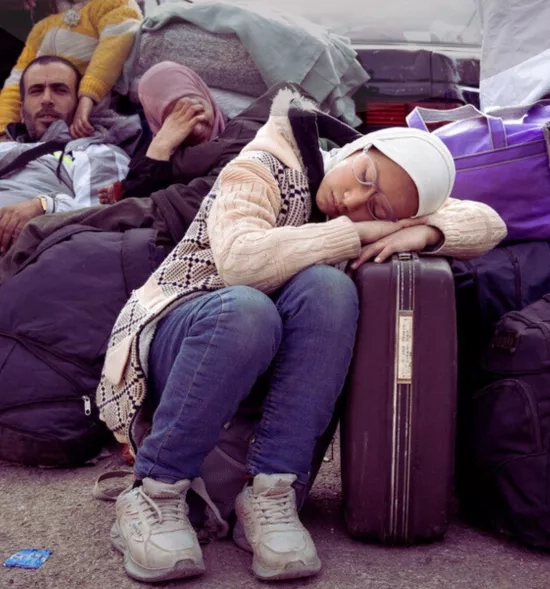 A 12 year old girl sleeps on a suitcase at the Masnaa crossing point, on the Syrian side of the border with Lebanon