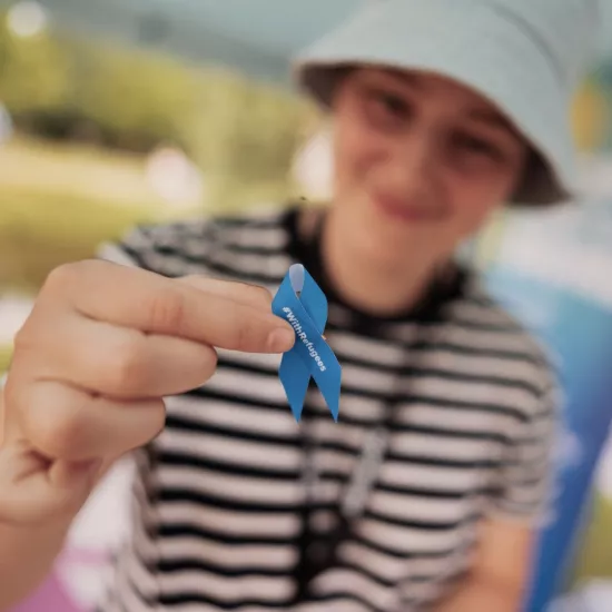 Boy holding solidarity ribbon in support of refugees and UNHCR