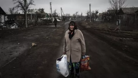 Ukraine.  Displaced Ukrainian carries the entirety of her belongings.