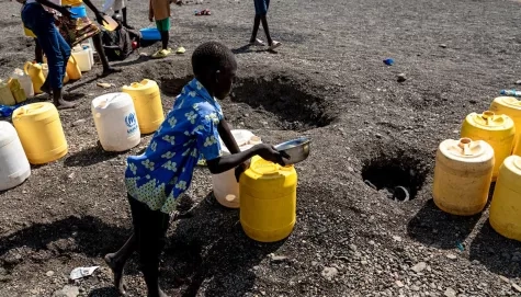 Children collect water from a dry riverbed ("laga) near Kalobeyei Settlement, Turkana county, Kenya