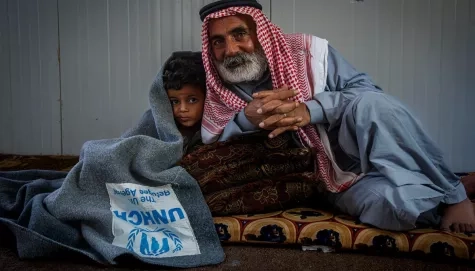 Jordan. Hassan 55 years old syrian refugee cuddling his 5 years old grandson with UNHCR blanket